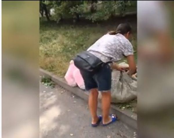 Жінка забрала в торби іграшки, які вінничани приносили щоб вшанувати пам’ять дітей, загиблих від російського ракетного обстрілу Вінниці. Відео                    
