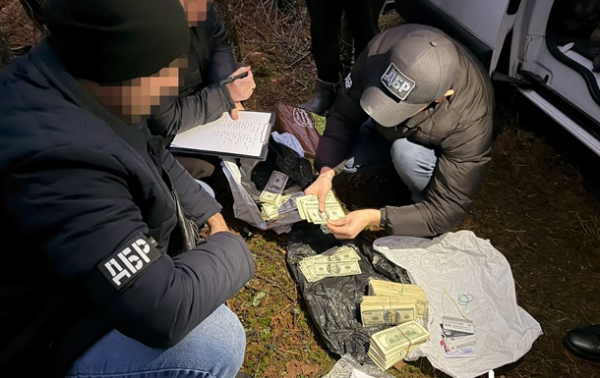 Ховався в лісі з грошима: київський поліцейський отримав підозру